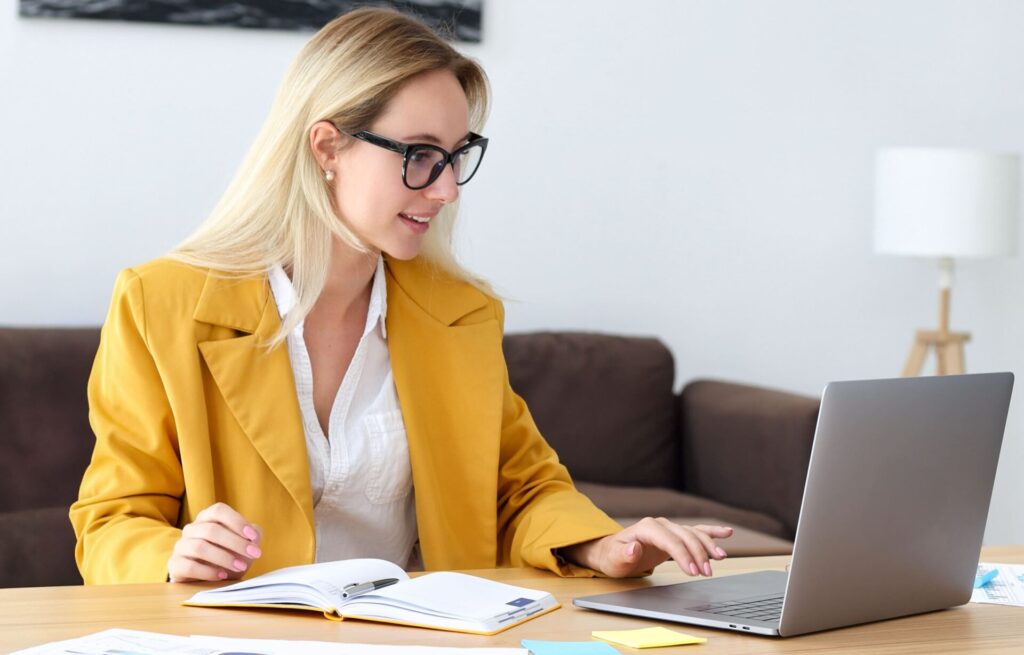 Frau mit gelbem Blazer am Laptop | ANG