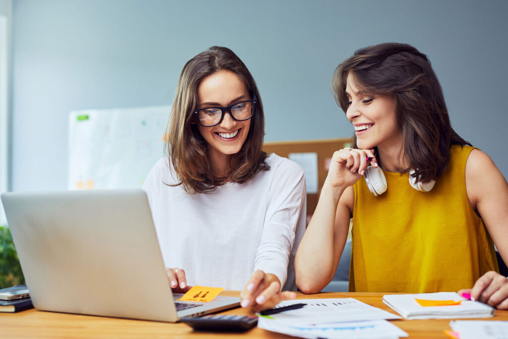 Two young women working together at office planning business | ANG