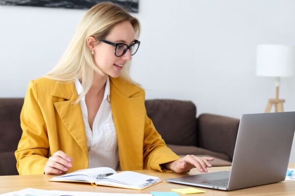 Frau mit gelbem Blazer am Laptop