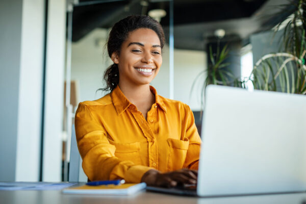 Happy-businesswoman-using-SAP-Business-One-while-sitting-at-workplace