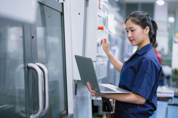 Maschinenbau-young-technician-engineer-worker-women-working-with-CNC-lathe-metal-machine-in-modern-steel-industry-factory